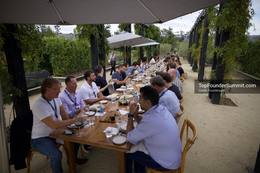Founders at the long farm to table lunch table under the vines